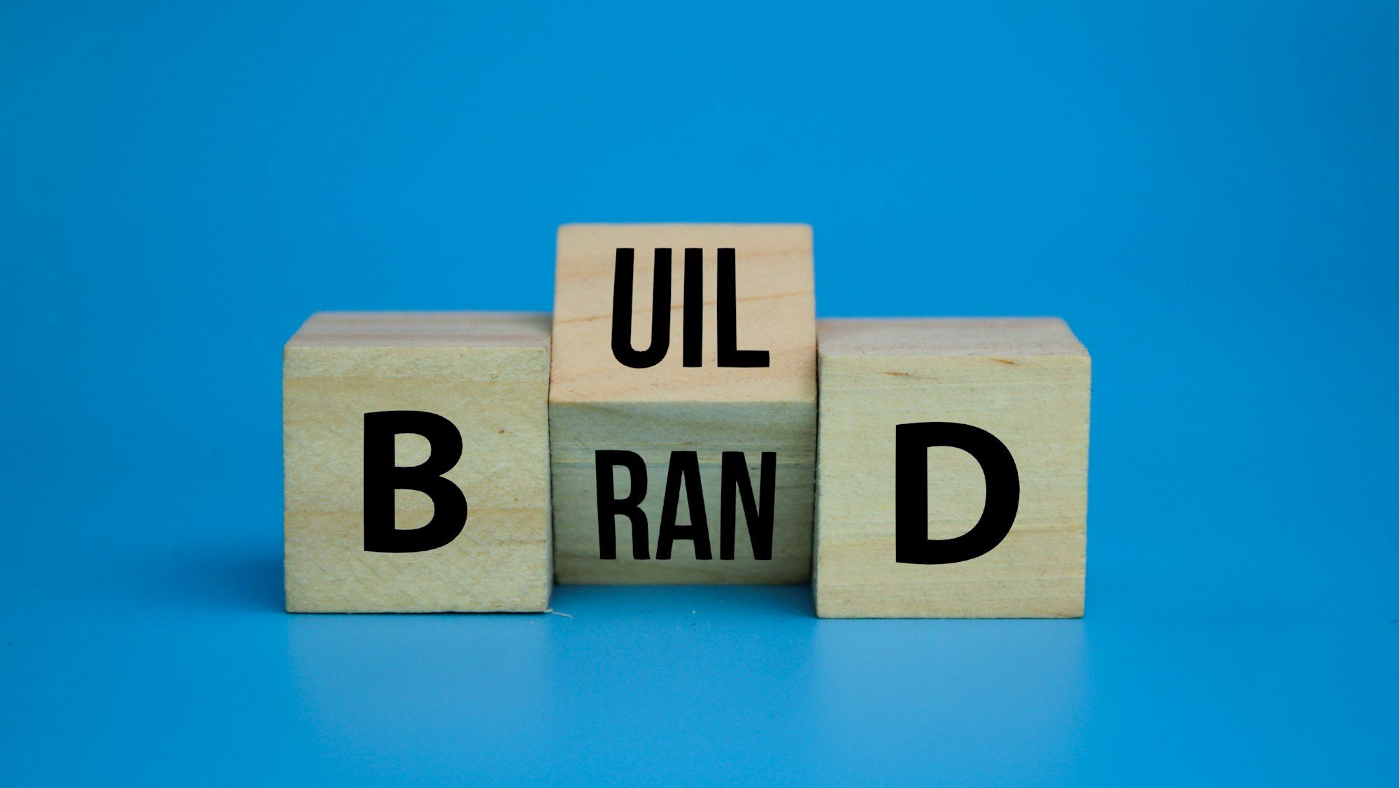 wooden cube with the word Build your brand symbol.