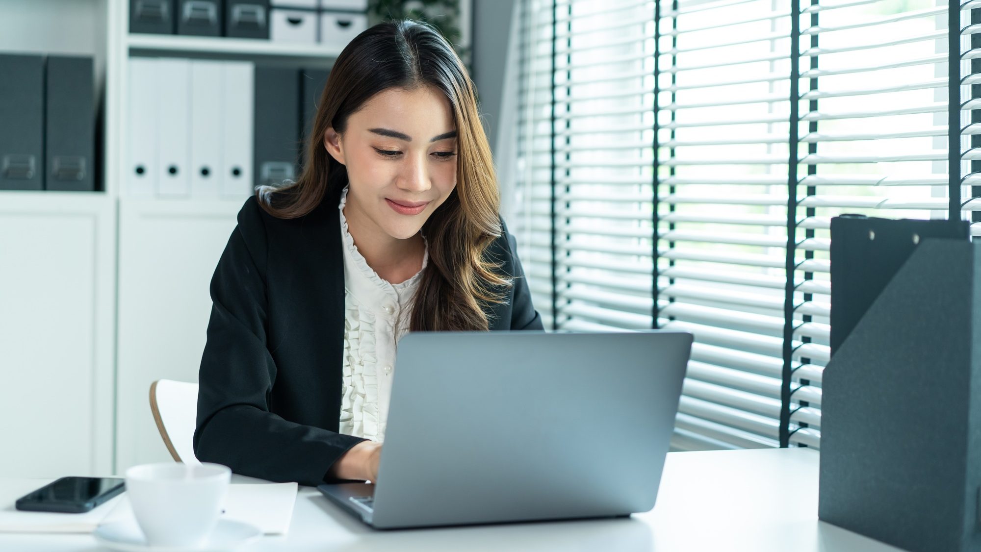Asian beautiful business woman smile feel happy while work in office.