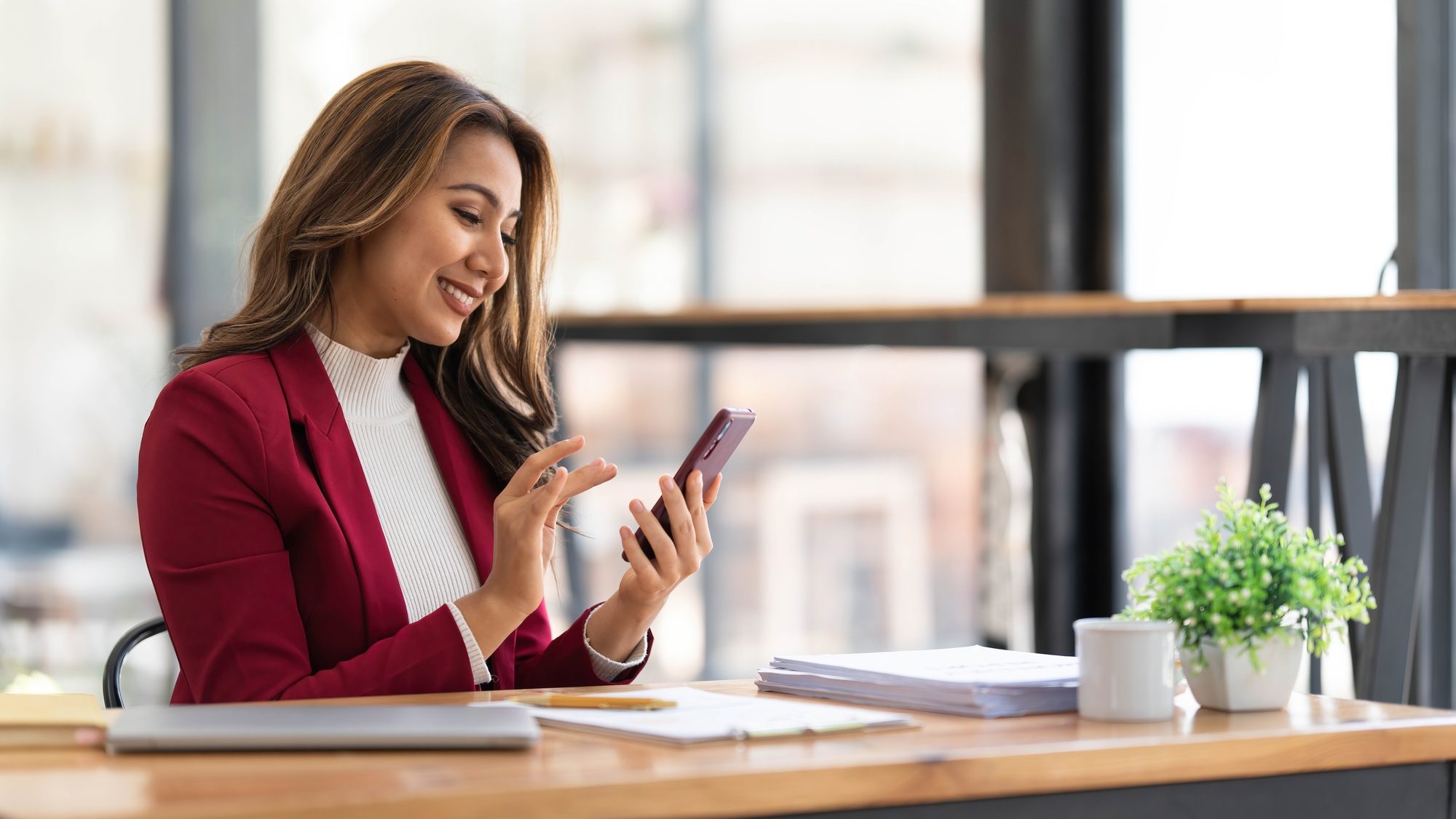 Smiling beautiful Asian businesswoman analyzing chart and graph showing changes on the market and