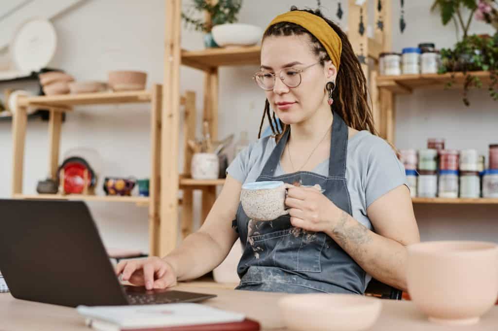 Young female freelancer or owner of small business sitting in front of laptop